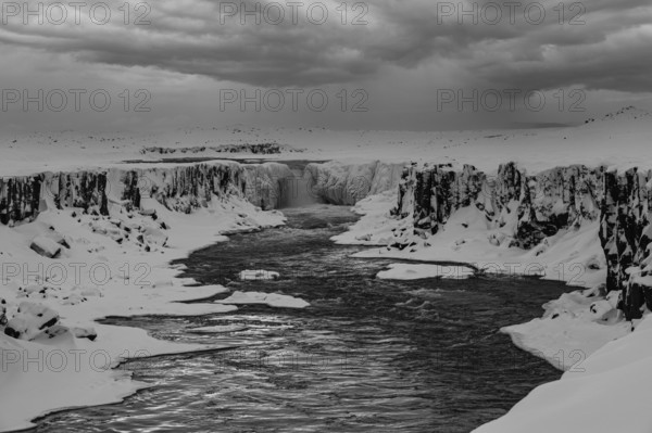 Selfoss waterfall with the river Jökullsa a Fjöllum, icy and snow-covered rock faces and shoreline,