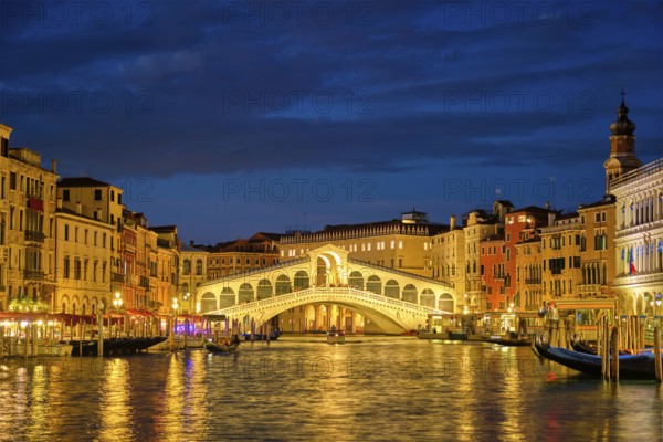 Famous Venetian tourist landmark Rialto bridge (Ponte di Rialto) over Grand Canal illuminated at