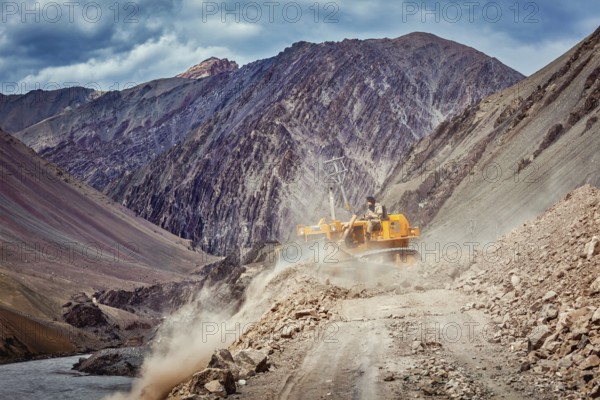 LADAKH, INDIA, SEPTEMBER 10, 2011: Bulldozer cleaning road after landslide in Himalayas. Ladakh,