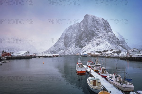 Pier with ships in Hamnoy fishing village on Lofoten Islands, Norway with red rorbu houses. With