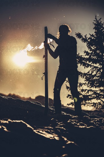 A woman's ski tour at sunrise on the Tegelberg in the Allgäu in the Ammergebirge, Bavaria, Germany,