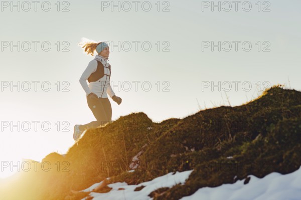 Trail running in autumn on the Jochberg on Lake Walchensee against the wonderful backdrop of the