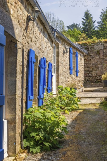 Narrow alley in an old idyllic French villages with picturesque stone houses and blue window