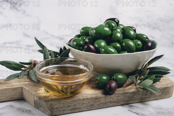 Chalkidiki olives, classic Greek green olives, in a bowl on a cutting board, top view, without