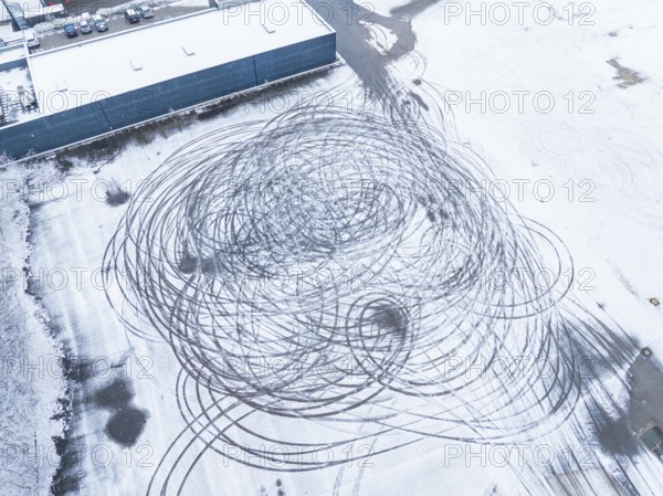 Tyre tracks form large circles on a snow-covered surface as seen from the air, Nagold, Black