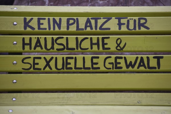 Green bench with the inscription No place for domestic and sexual violence, seen in Burghausen,
