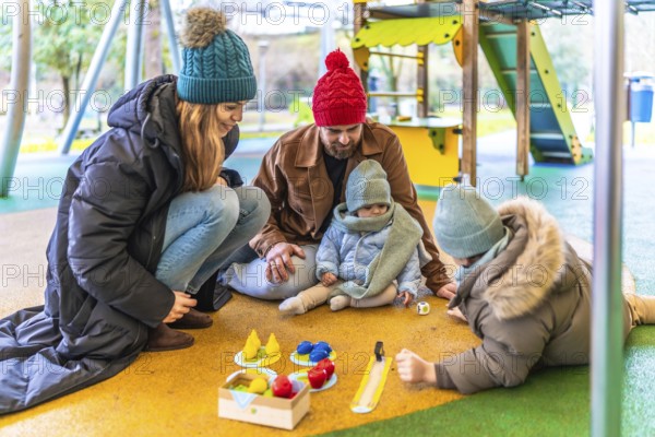 Happy family enjoying quality time together, playing board game at an outdoor playground during