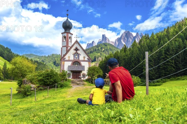 Father and son admiring the stunning view of the idyllic st. Magdalena church in the picturesque