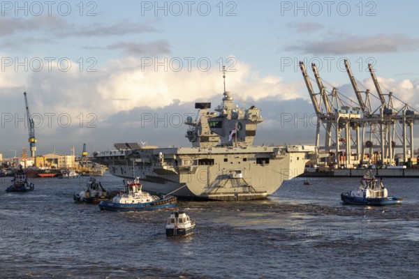 Harbour tug and aircraft carrier HMS Queen Elizabeth, warship of the British Royal Navy on the
