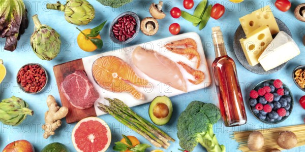 Food, overhead panorama on a blue background. Meat, fish, seafood, poultry, wine, cheese,