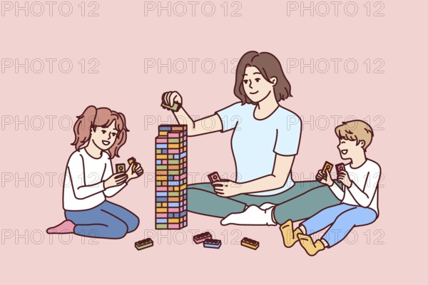 Woman babysitter together with kids plays constructor building tower of children blocks in