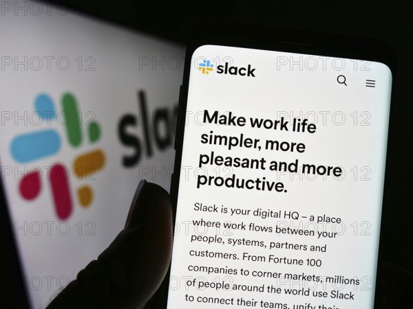 Stuttgart, Germany, 12-30-2022: Person holding cellphone with webpage of US software company Slack