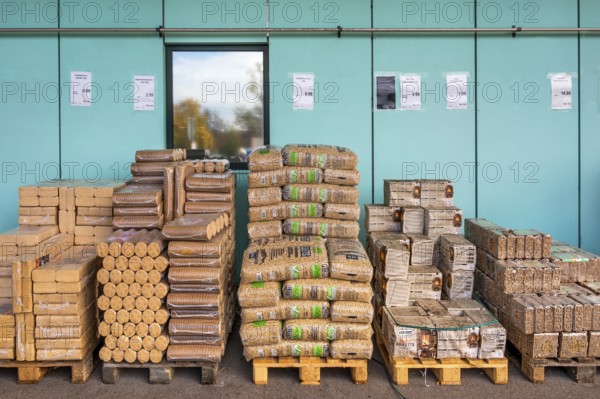 Plastic bags with wood pellets, wood briquettes and firewood at a wholesale market, Allgäu,