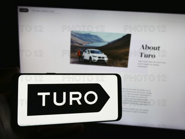 Stuttgart, Germany, 03-18-2024: Person holding smartphone with logo of US peer-to-peer carsharing