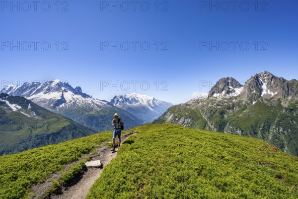 Mountaineer on hiking trail, mountain panorama with glaciated mountain peaks, Aiguille Verte with