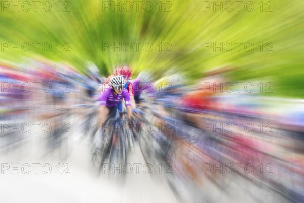 Cyclist in sportswear and helmet riding at high speed on a road, race, the motion blur emphasises