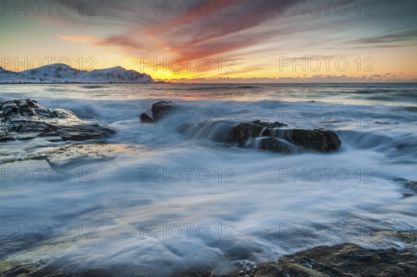 Long exposure, sunset in winter at Skagsanden, rocks washed over by the sea on the beach at