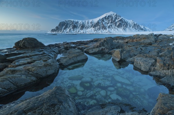 Long exposure, winter at Skagsanden, rocks washed over by the sea on the beach at Flakstad,
