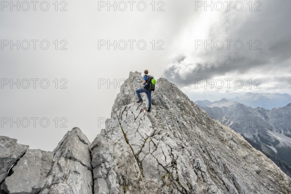 Mountaineer on a narrow rocky ridge, Watzmann crossing to Watzmann Mittelspitze, view of mountain
