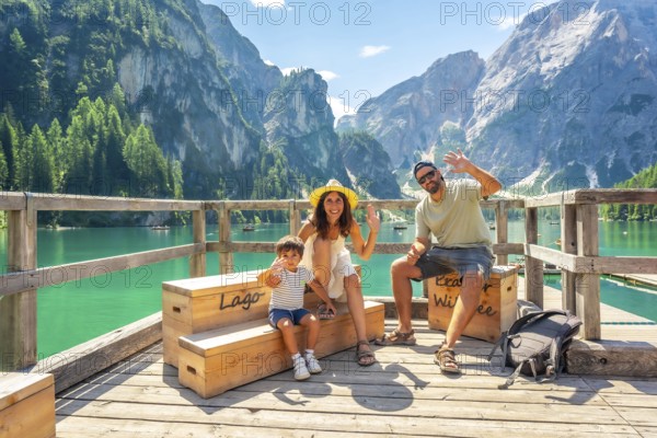 Happy family waving at lake braies, also known as pragser wildsee, enjoying summer vacation amidst