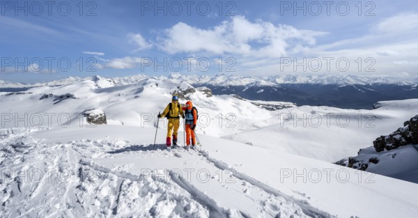 Couple, two ski tourers at the summit Wisshore with mountain panorama, snowy mountain landscape,