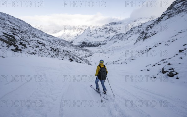 Skiers skiing downhill in a snow-covered mountain landscape in the Madritschtal valley, Ortler