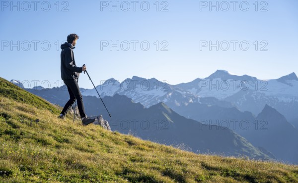 Hiker enjoying the mountain panorama in the morning, Venediger group, behind Dreiherrenkopf,