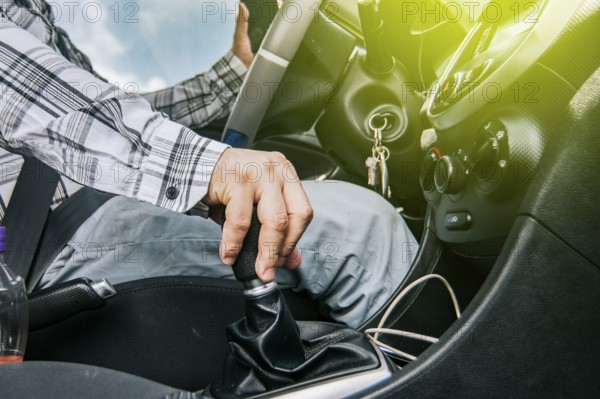 Close up of a man's hand on the gear lever of a car, concept of speed and gear lever, close up of