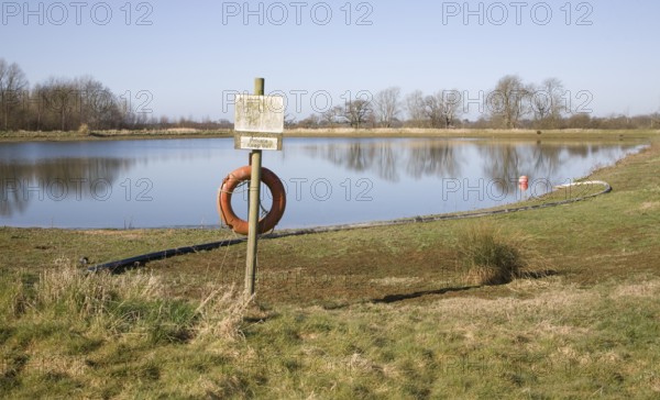 Orange life saving ring by irrigation water reservoir, Sutton, Suffolk, England, United Kingdom,