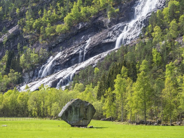 Waterfall Vidfossen, single large rock Oddmundsteinen, south of town Odda at fjord Sørfjord, branch