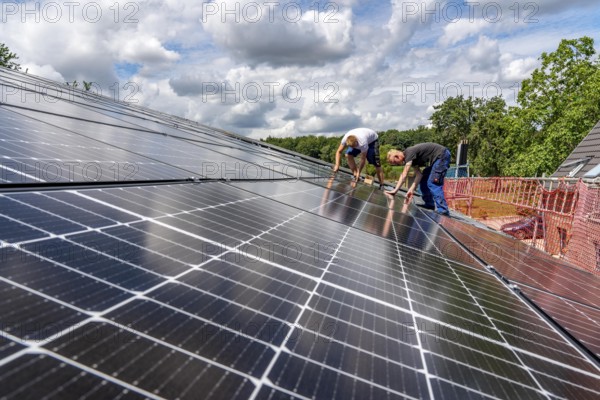 Installation of solar modules on the roof of a barn on a farm, over 210 photovoltaic modules are