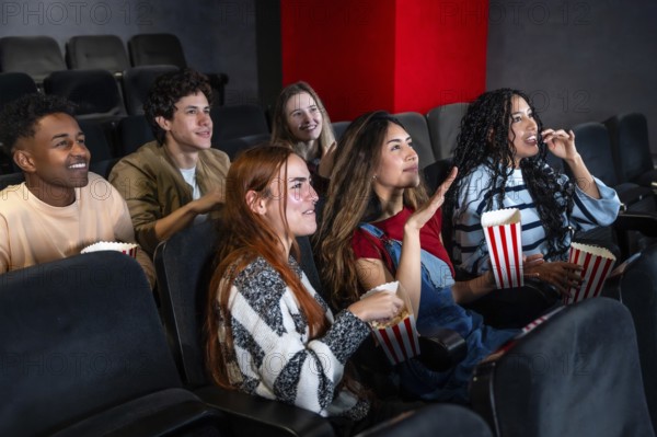 Friends enjoying a film in a movie theater, munching on popcorn and sharing laughter, creating