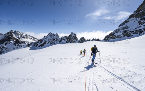 Ski tourer with rope, rope team on the Vadret da Porchabella glacier on the ascent to the summit of