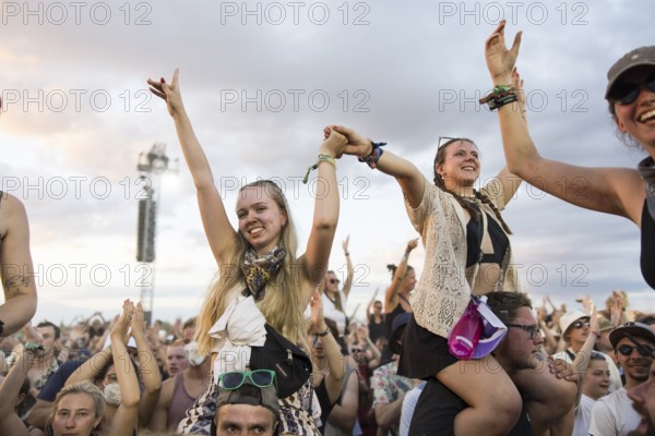 Festival visitors are carried on shoulders during the performance of the band Feine Sahne