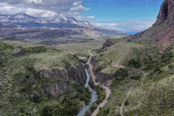 Canyon of river Rio Claro, gravel road along the river, view towards mountain range at Puerto