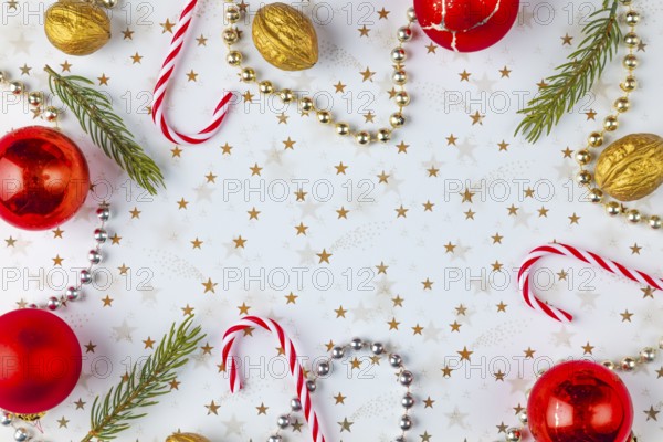 Frame made of Christmas decorations, fir branches, baubles, nuts on a white background with golden