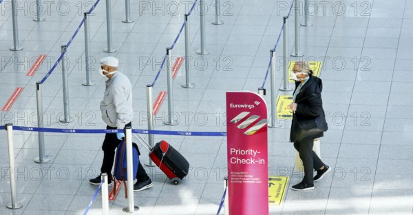 Passengers wearing face masks at the Eurowings check-in counter at Düsseldorf Airport during the
