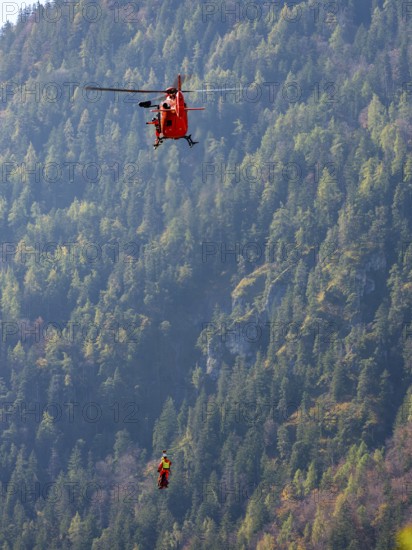 2 mountain rescuers of the Bavarian Mountain Rescue Service are winched by the on-board mechanic of