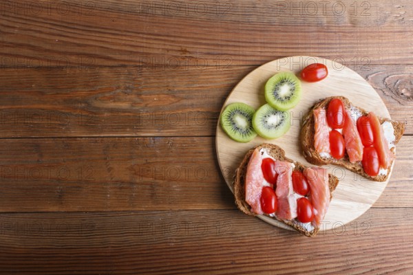Smoked salmon sandwiches with butter on wooden background. cherry tomatoes. top view, copy space