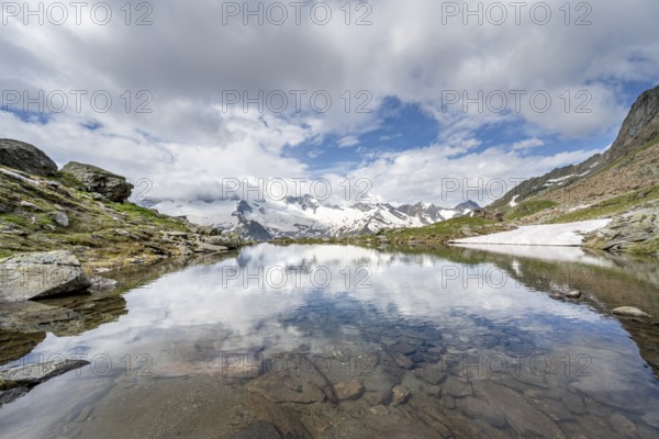 Picturesque mountain landscape with mountain lake, mountains and glaciers reflected in the