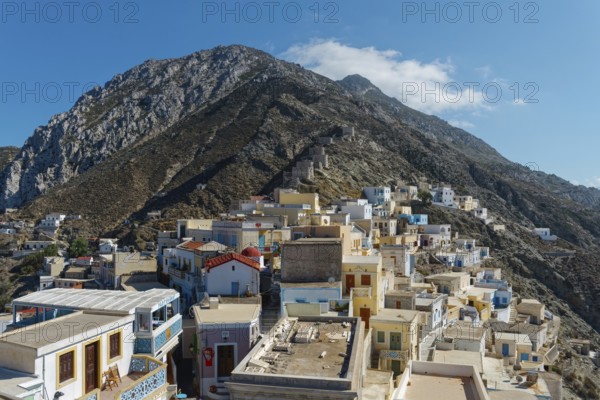 Colourful houses of the picturesque village of Olymbos spread out on a mountainside under a clear