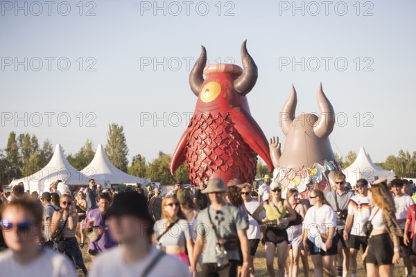 Festival visitors in front of the Highfield mascot Highviech at the Highfield Festival on Friday,
