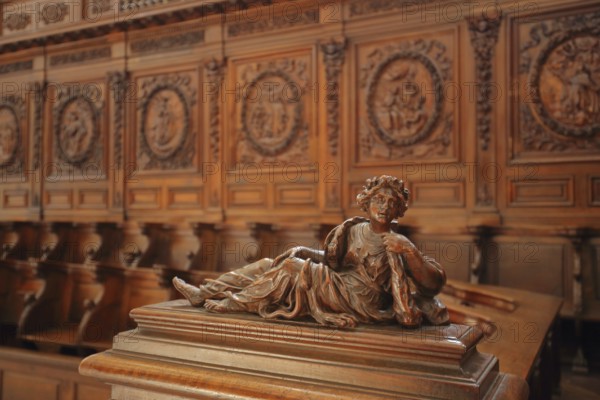 Wooden figure and reliefs on the choir stalls of the Gothic church of Ste-Marie-Madelein, interior