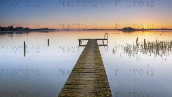 Wooden footbridge at sunrise on Lake Schaalsee, Schaalsee Biosphere Reserve, Zarrentin,