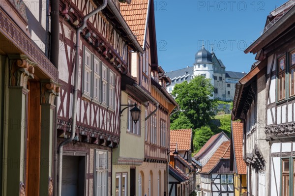 Street with half-timbered houses in the old town, the castle in the background, Stolberg im Harz,