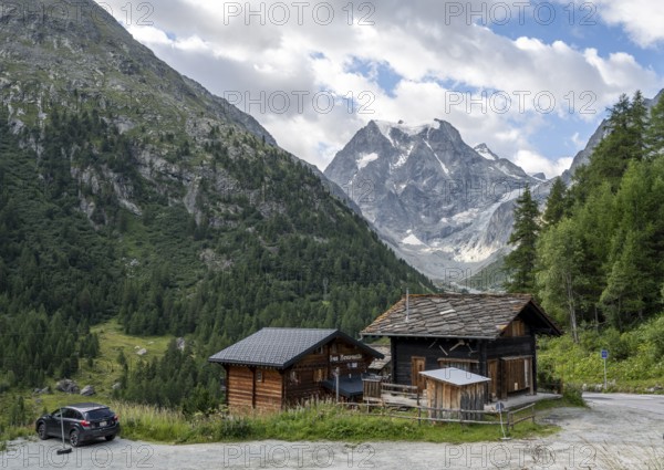 Wooden houses in the mountain village of Arolla, behind mountain peak Mont Collon, Valais, Western