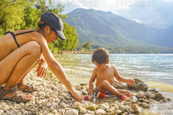 Mother and son enjoying quality time together, playing with pebbles and toy cars on the scenic