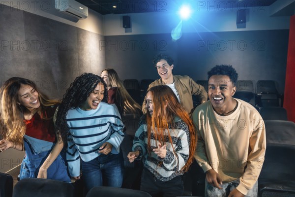 Happy multi ethnic friends dancing and celebrating together at a lively movie disco event in the