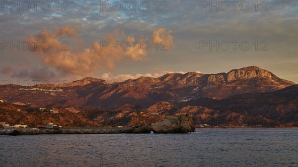 Impressive coastal scene at sunrise with mountains and dramatic clouds in the sky, Pigadia, town