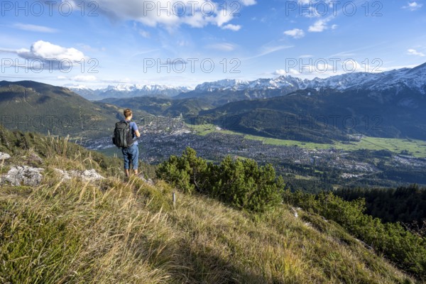View of Garmisch-Partenkirchen and mountain panorama, mountaineer on hiking trail to Kramerspitz,